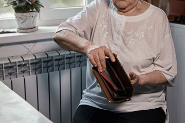 Kvinna som håller upp en tom plånbok
